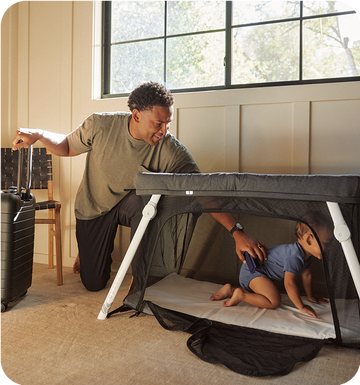 The Lotus Travel Crib setup with a young family using it while they travel